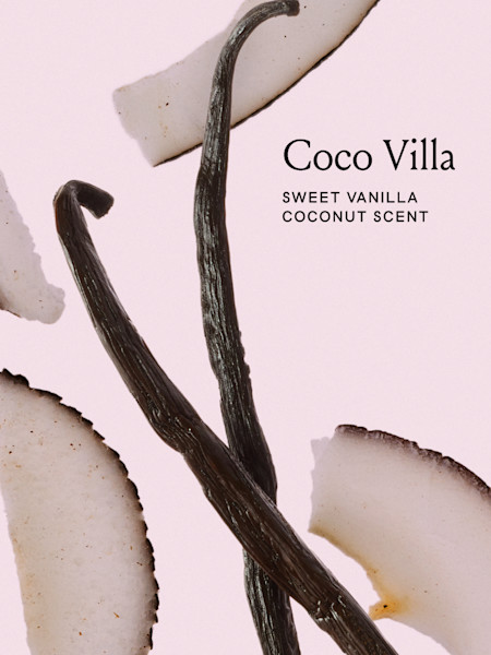 Vanilla beans and coconut slices on pink background for Coco Villa fragrance product with sweet vanilla coconut scent.