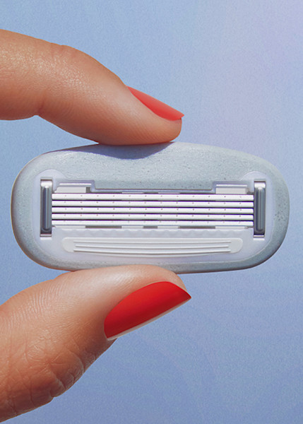 model hand holding a single razor blade