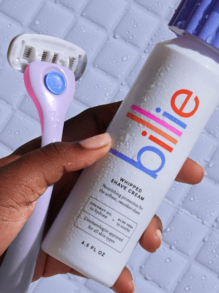 model holding lavender whipped shave cream with pink, periwinkle and purple razor