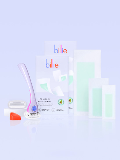 Purple and pink razor with an extra blade and holder alongside face & bikini wax kit box and strips and body & underarm wax kit box and strips against a light gray background