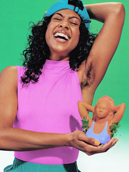 Person in pink top and blue cap laughing joyfully while holding a small figurine against bright green background.
