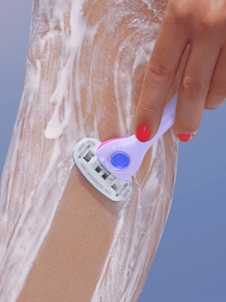 model shaving leg with shave cream and purple razor handle