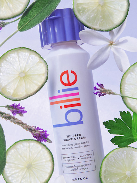 bottle of whipped shave cream with flowers and lime slices