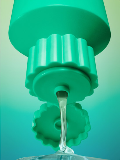 Close-up texture photograph of Billie Detox Body Wash being squeezed out of the bottle on a green gradient background