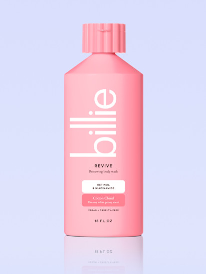 Pink bottle of Billie Revive body wash with text detailing Vitamin E and Shea Butter ingredients against a light blue background.