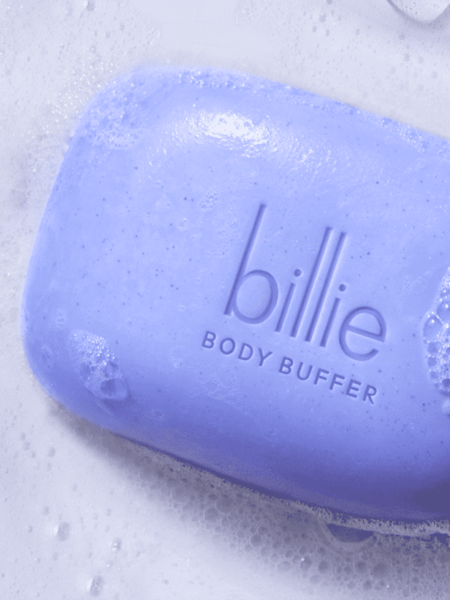 purple body buffer bar on a background of sudsy soap