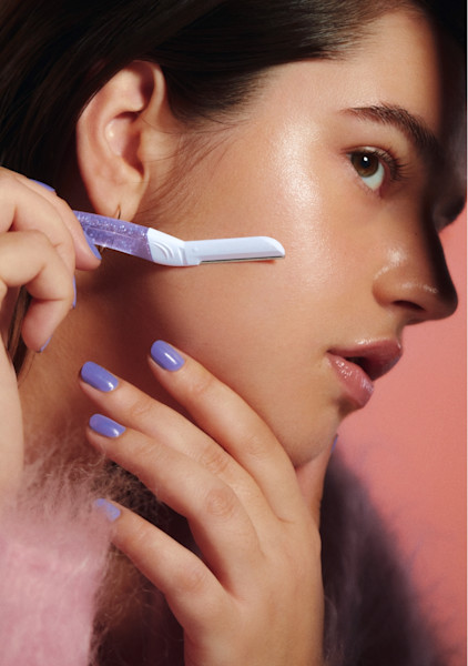 model using sparkle dermaplane on her cheek