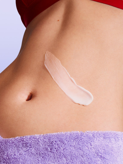 Woman applying Billie Sendi Body Lotion to her stomach.