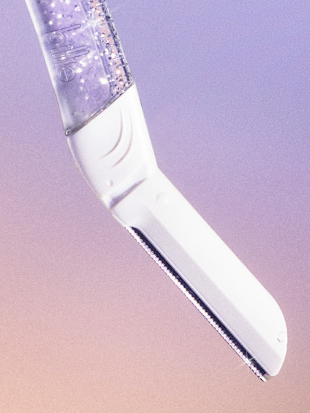 sparkle dermaplane handle and blade in front of a light purple background