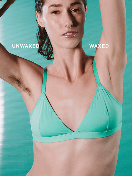 Woman in a teal bra against a teal background showing before and after of underarm with waxed and unwaxed armpit