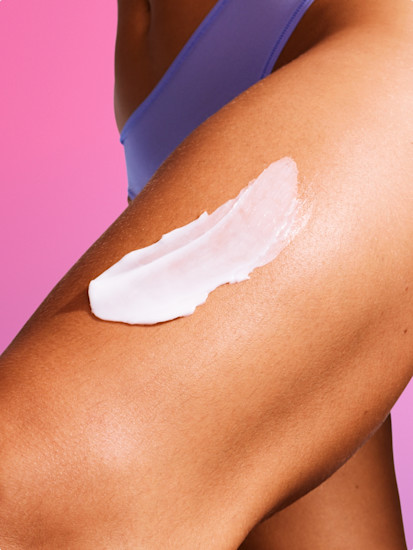 Woman applying Billie Soothe Body Lotion to her thigh.