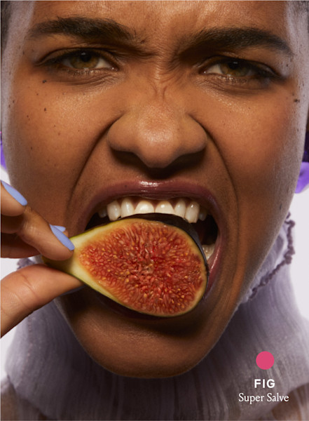 model taking bite out of a fig