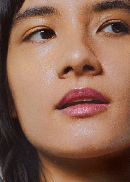 Model wearing light pink tinted lip balm