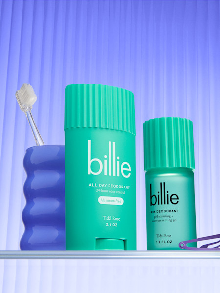 stylized tidal rose aha and all day deodorants next to a blue cup with a clear toothbrush and a purple hair clip